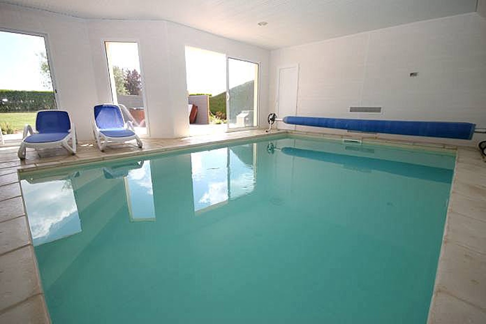 La piscine intérieure de la Villa Groix avec transats